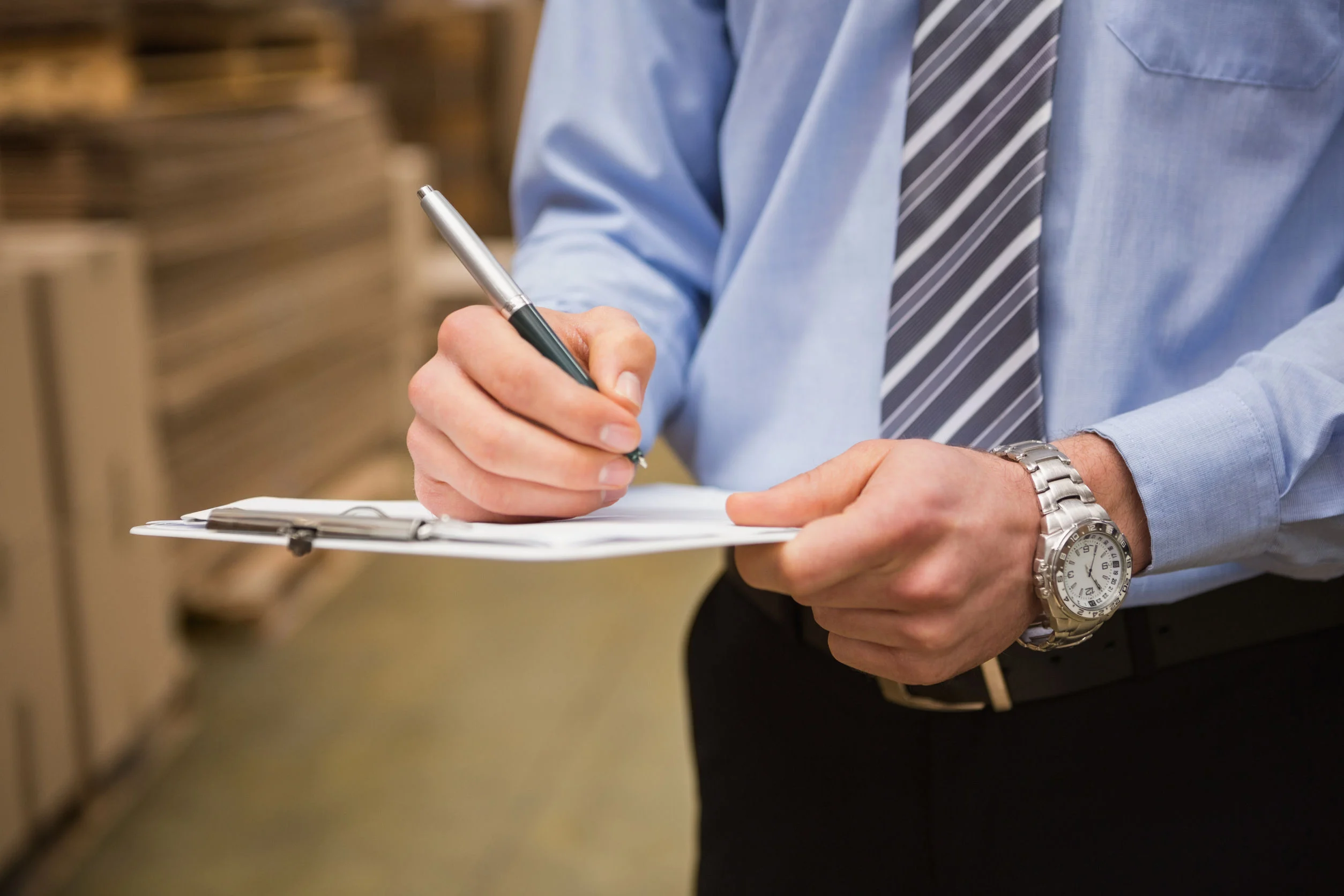 Business professional writing on a clipboard