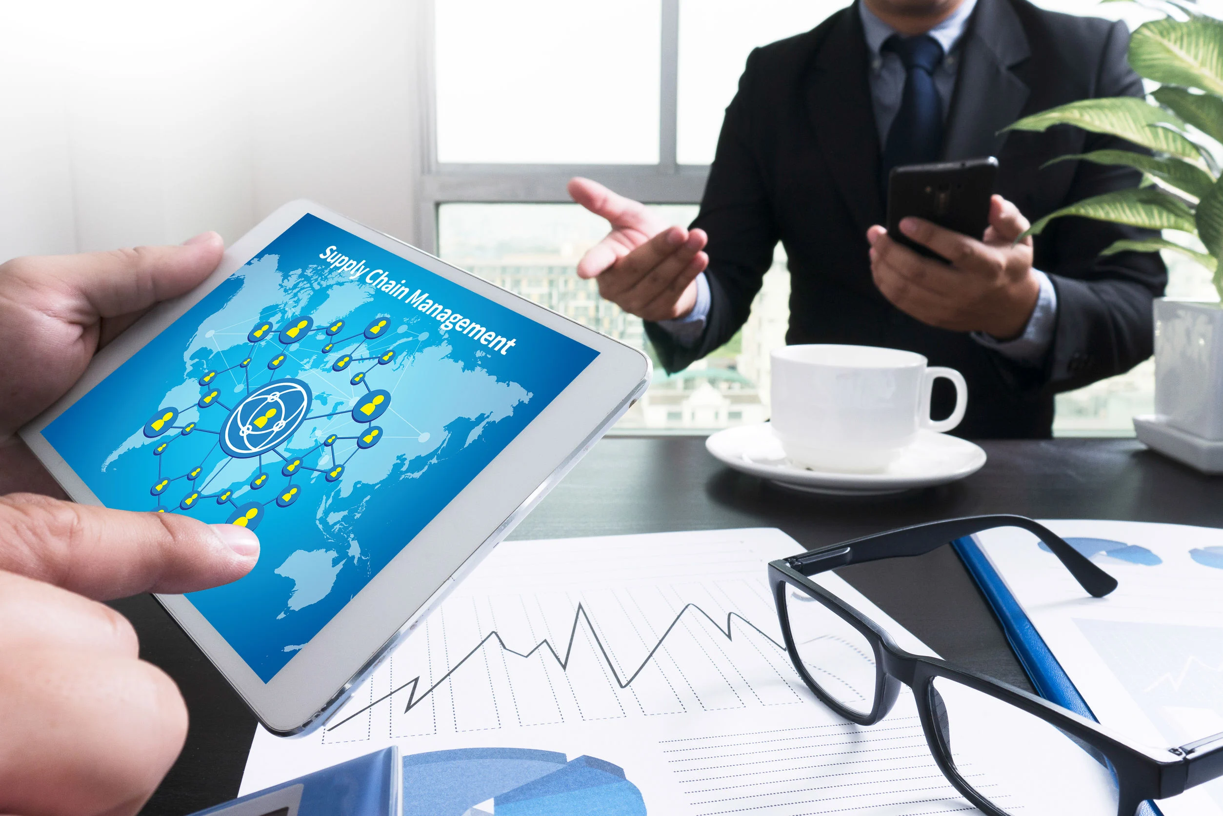Business team reviewing global supply chain data on a tablet