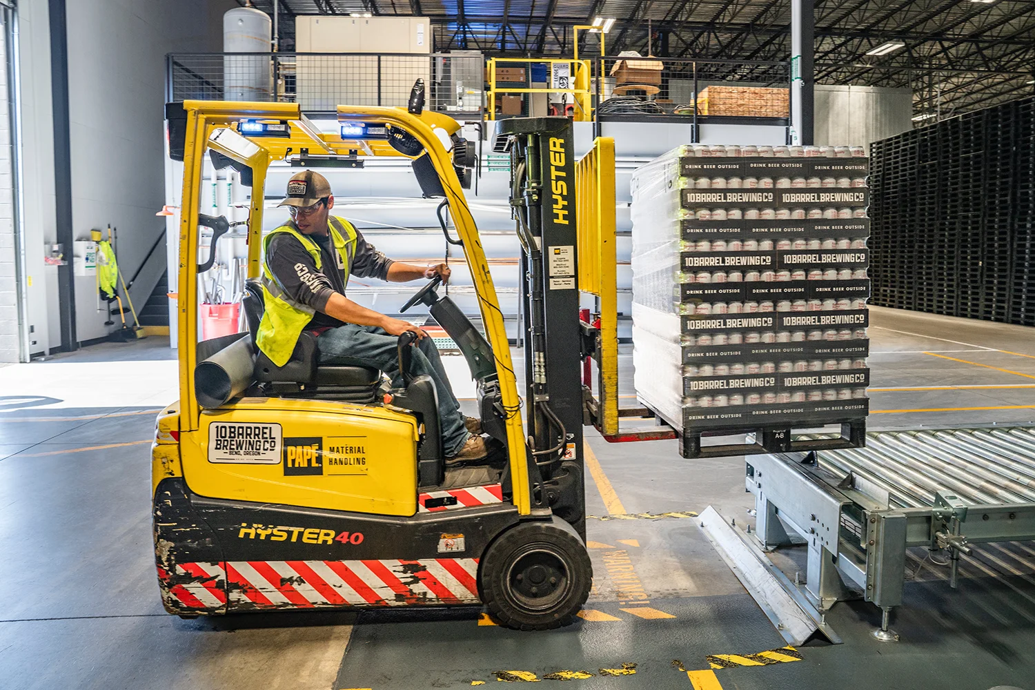 Forklift operator moving a pallet in a warehouse
